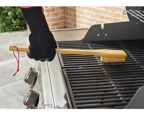 Grillborste med trähandtag rengör ett grillgaller