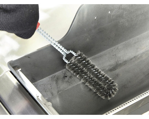 En grillrengöringsborste med stålborst används för att rengöra en grill.