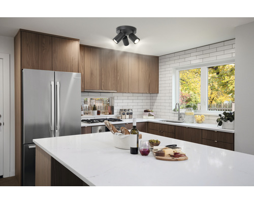 Kök med köksskåp, köksö och taklampa med tre lampor