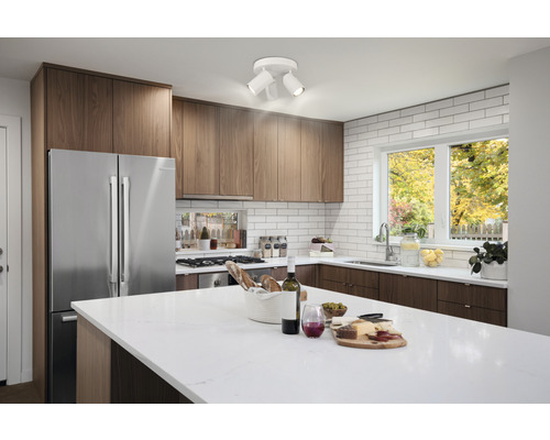 Modernt kök med köksbord, inbyggda skåp, kylskåp och taklampa