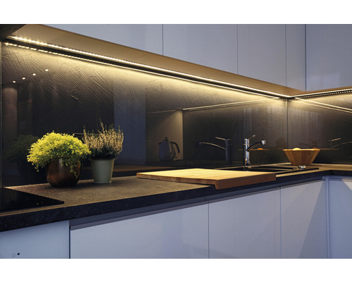 Köksscen med bänkskiva, diskho, armatur, skärbräda, växter och LED-belysning