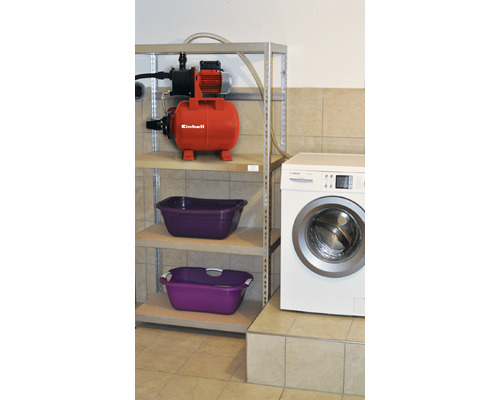 Scen med hydrofor på hylla, tvättmaskin och tvättkorgar