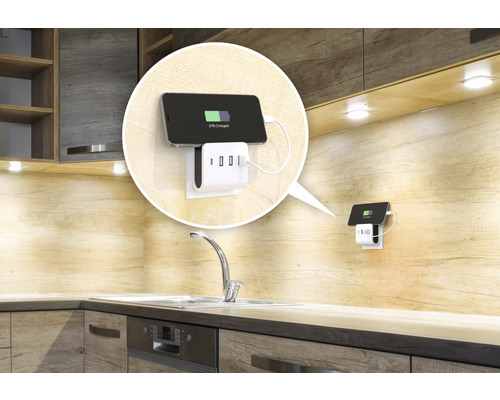 Grenuttagsadapter med USB-portar och mobiltelefon i en köksmiljö.