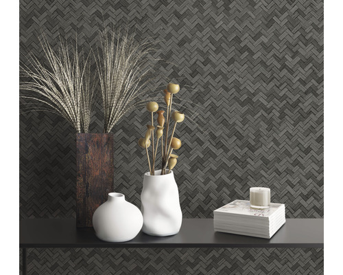 Dekorativt stilleben med vaser, bok och ljus mot en mönstrad vägg