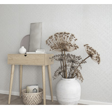 Dekorativ scen med träbord, vit vas med blommor och geometrisk tapet