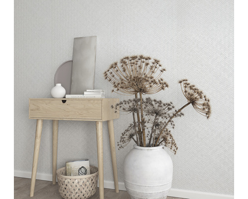Dekorativ scen med träbord, vit vas med blommor och geometrisk tapet