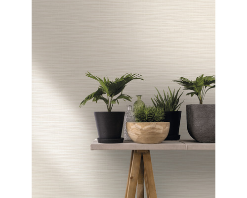 Ljus non-woven tapet med horisontellt randigt mönster i rummet med växter på ett bord