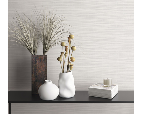 Dekorativt stilleben med vaser, prydnadsgräs, bok och ljus på en hylla