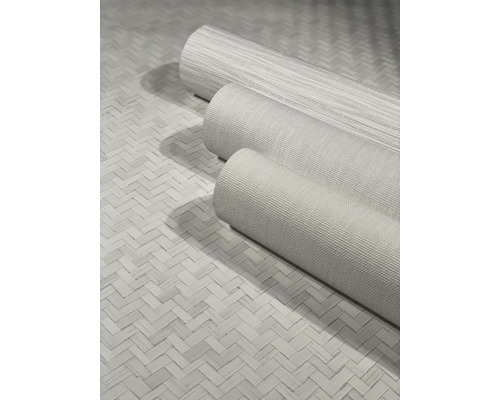 Tre rullar textilfibertapet på en flätad bakgrund.