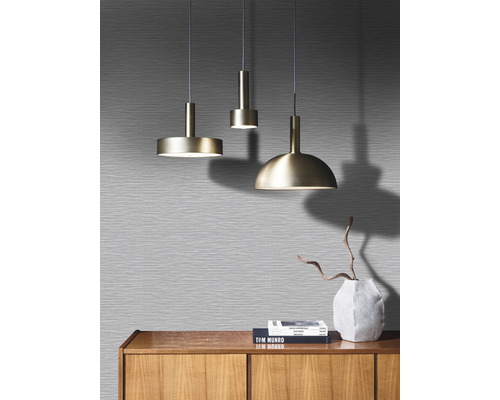 Tre metallhänglampor över ett träskåp