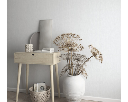 Dekorativ scen med ett sidobord i trä, en vas med torkade blommor och dekorativa tillbehör.