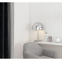 Dekorativt vardagsrum med grå fåtölj, silverlampa och blommiga accenter