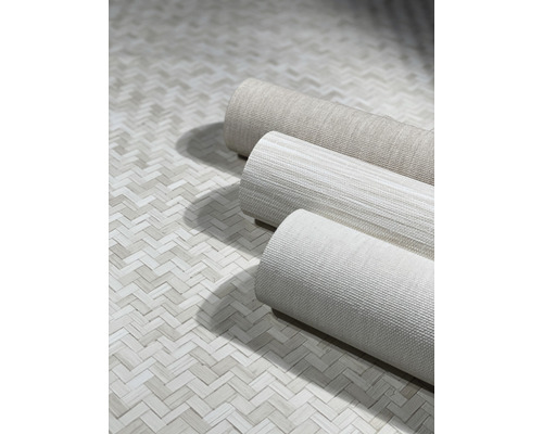 Tre rullar textil tapet på ett golv med fiskbensmönster