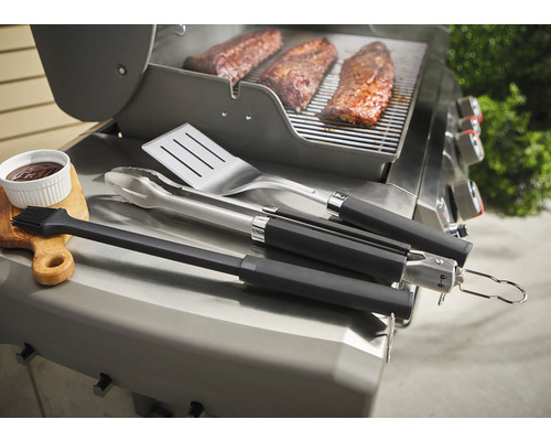 Grillscen med grillverktyg, revbensspjäll och sås