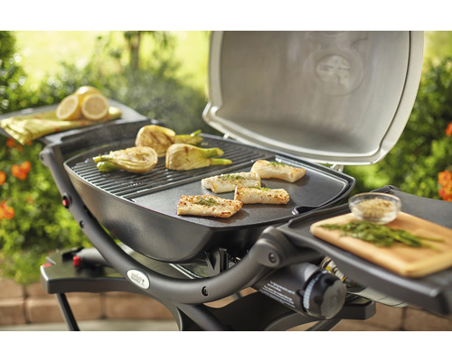 Weber grill med fisk och grönsaker tillagade på grillgallret