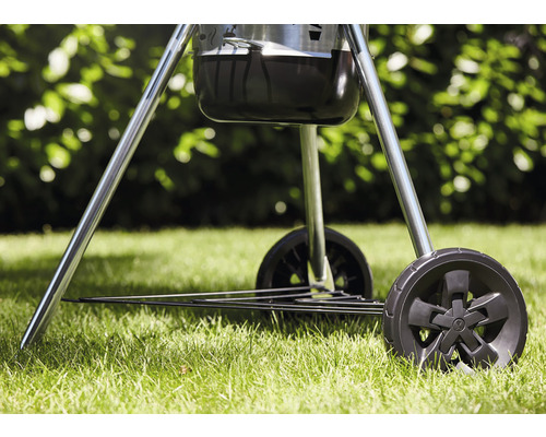 Detaljvy av en kolgrill med hjul på gräsmatta