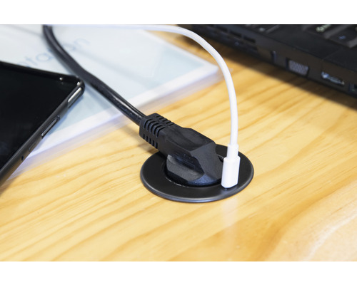 Kabelgenomföring på ett träbord med elektroniska apparater