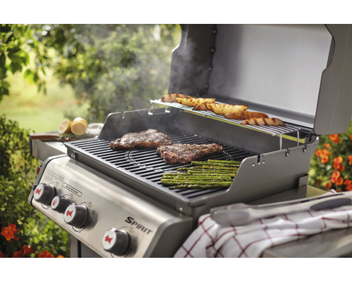 Grill med biffar, sparris och potatis på gallret utomhus