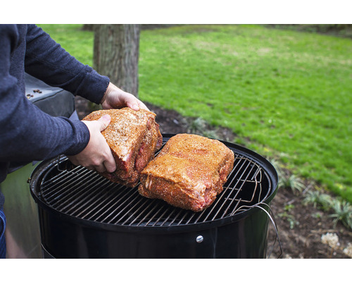 Två köttbitar placerade på en rund grill