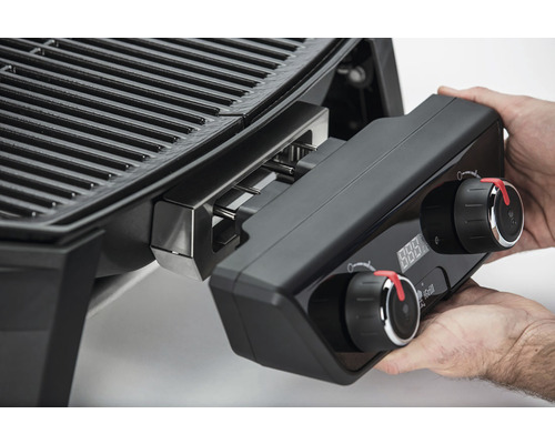 Närbild av en elektrisk grill med kontroller som hålls i handen.