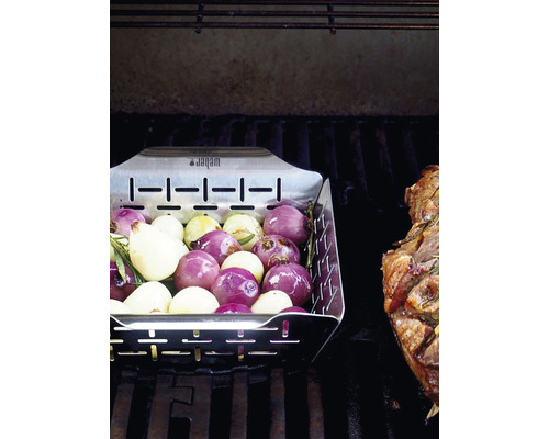 Grillkorg med grönsaker på en grill med kött.