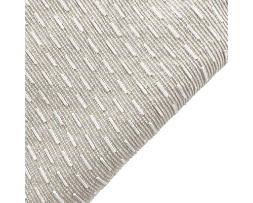 Närbild av en kudde med broderat mönster