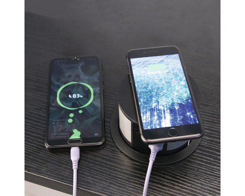 Två smartphones laddas med en infälld laddare.