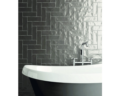 Badrum med badkar och väggplattor i fiskbensmönster