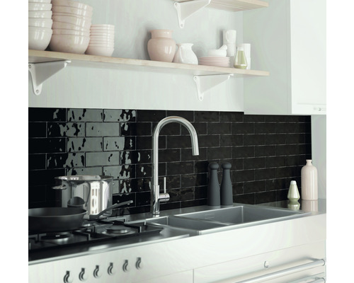 Köksscen med diskho, armatur, spishäll och svart kakel