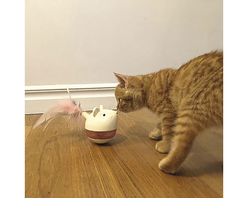 En orange katt tittar på en leksaksmus med fjäder på ett trägolv.