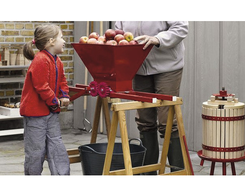 Äppelpress i användning med barn och vuxen i trädgården