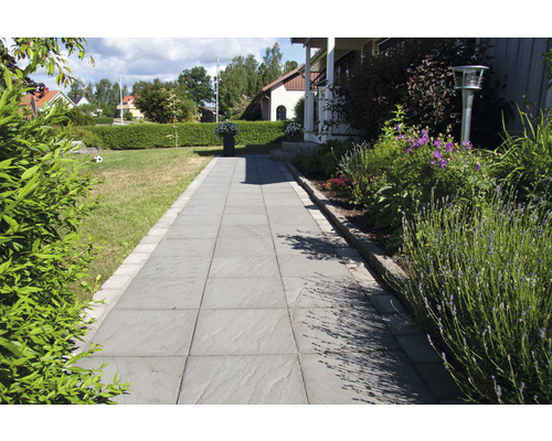 Trädgårdsväg med stenplattor och gräsytor