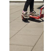 Närbild av ett barn på en röd barnscooter.