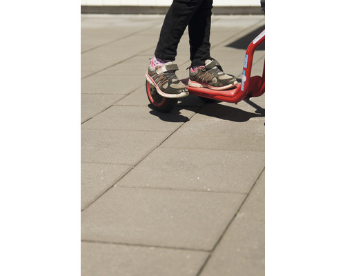 Närbild av ett barn på en röd barnscooter.