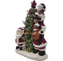 Juldekoration med jultomte, snögubbe, teddybjörn och ren bredvid en julgran