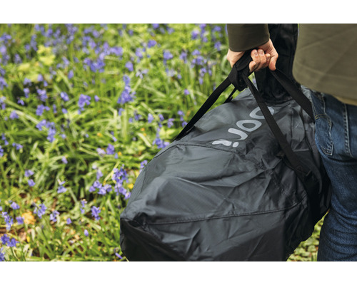 Person bär en förpackad bärbar trädgårdsdusch utomhus