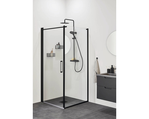 Badrum med duschkabin med svart ram, duscharmatur och tvättställ