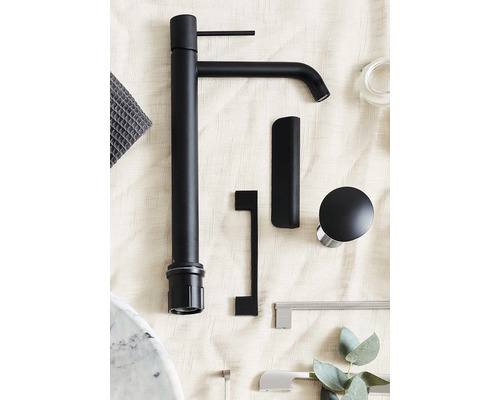 Svart kran, möbelhandtag och tillbehör på ljus bakgrund