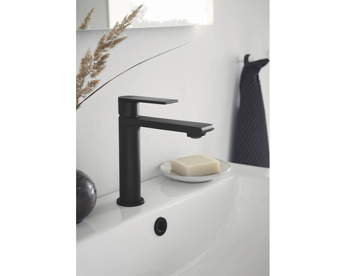 Svart tvättställsblandare på ett vitt handfat i badrummet.