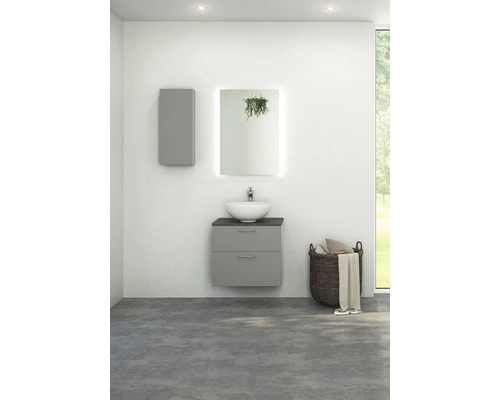 Ljust badrum med tvättställsskåp, tvättställsskål, spegelskåp med belysning och tvättkorg