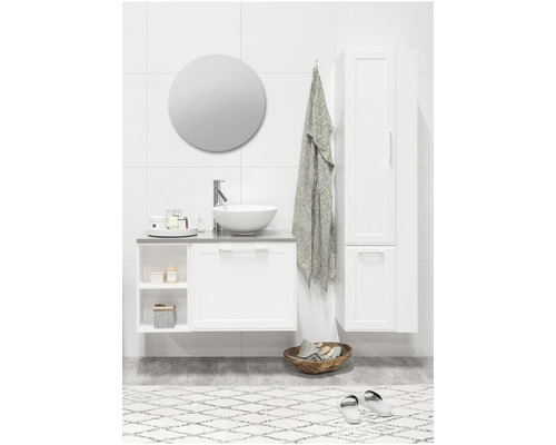 Ljust badrum med handfat, underskåp, spegelskåp och rund spegel