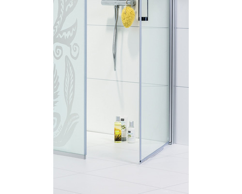 Duschkabin med blommönster och duschartiklar i ett ljust badrum