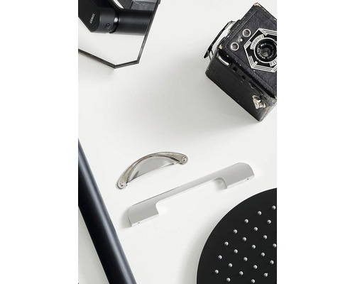 Scen med två möbelhandtag av olika design, en duschstång och ett duschhuvud