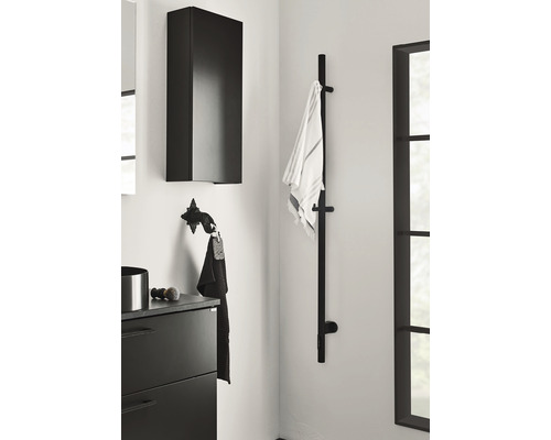 Badrum med tvättställsskåp, väggskåp och handdukshållare.