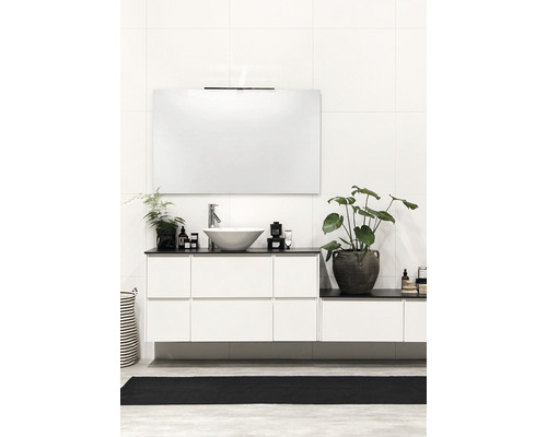 Ljust badrum med tvättställ, spegel och växter för en vänlig atmosfär