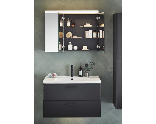 Badrum med tvättställsskåp, handfat och spegelskåp för badrumsartiklar.