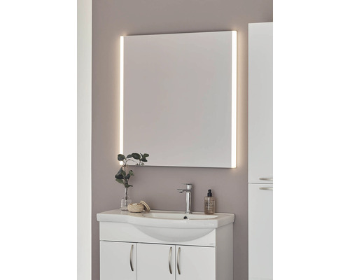 Badrum med tvättställsskåp, armatur och belyst spegel