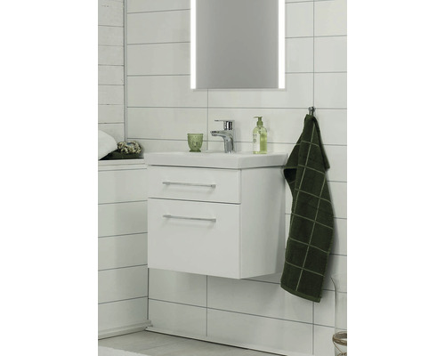 Badrum med tvättställsskåp, tvättställ, belyst spegel och handduk