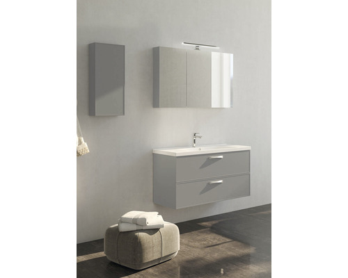 Modernt badrum med underskåp för tvättställ, spegelskåp och högskåp.