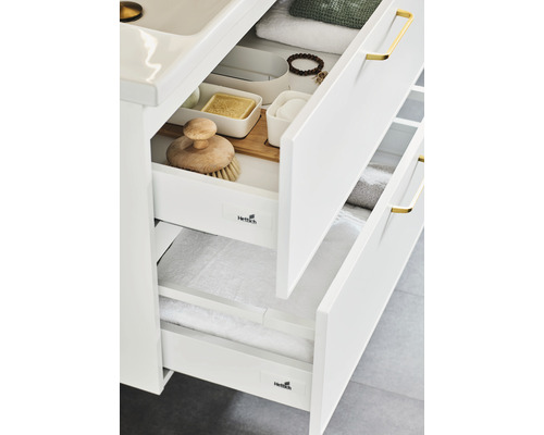 Detaljvy av ett badrumsskåp med öppna lådor för förvaring av badrumsartiklar och handdukar